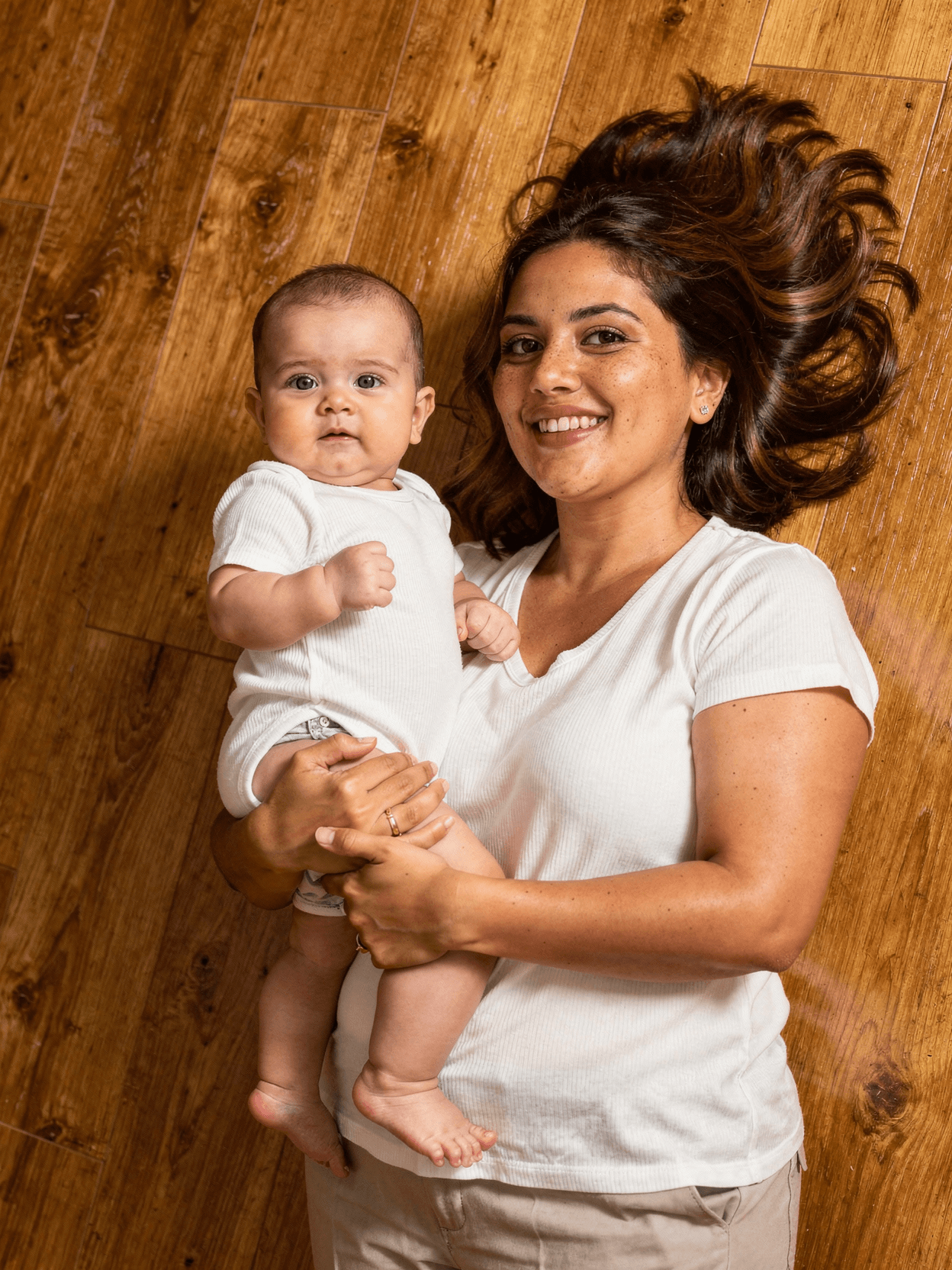 White Polyester Baby Onesie Mockup on Model — Overhead Lifestyle Shot