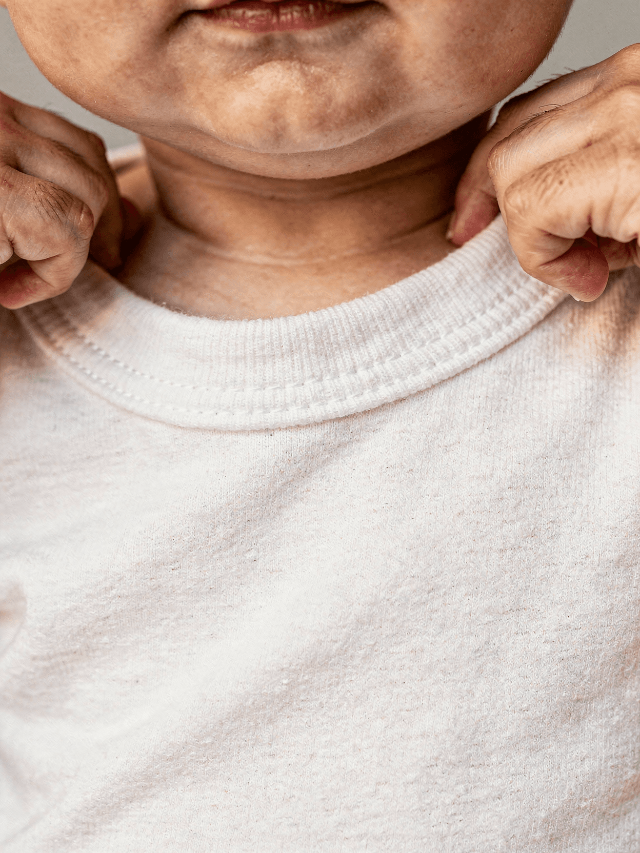 White Cotton Baby Onesie Mockup on Model - Park — Neckline & Collar Detail